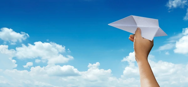 person holding a paper plane